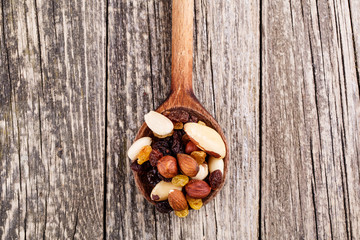 Mixed nuts on a wooden spoon.