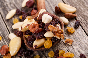 Mixed nuts on a wooden spoon.