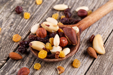 Mixed nuts on a wooden spoon.