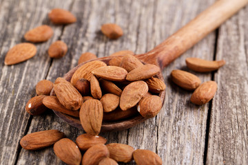 Almonds on a wooden spoon.