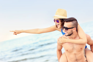 Young couple pointing at something at the beach