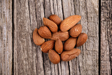 Brazil nuts on a spoon on wooden background.