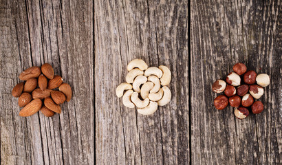 Brazil nuts on a spoon on wooden background.