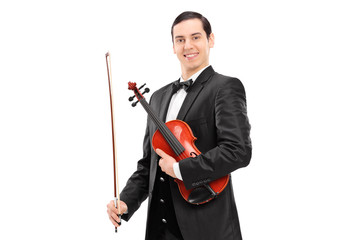 Young confident violinist in black suit holding a wand and a vio