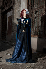 Fototapeta na wymiar Gothic redhead woman walking with candle