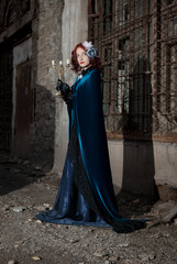 Naklejka premium Gothic redhead woman walking with candle