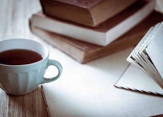 Tea. Books, flowers and white cup on wooden table