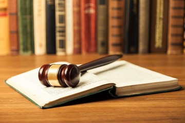 Law. Open law book with a judges gavel resting on top of the