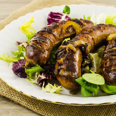 Roasted sausage with vegetables on jute background