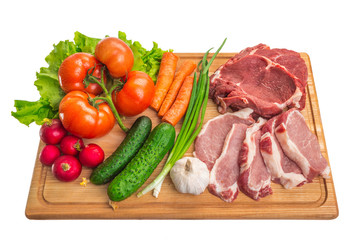 Fresh raw meat and vegetables on a cutting board