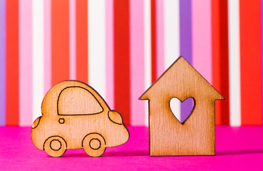 Wooden house with hole in the form of heart with car icon on red