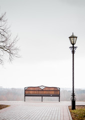 Bench and lantern in the park. misty landscape