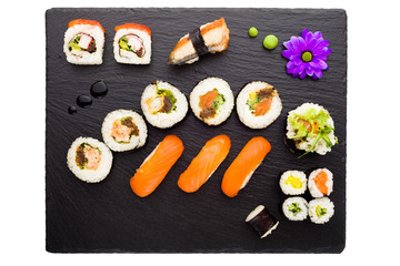 Sushi on black stone plate isolated top view
