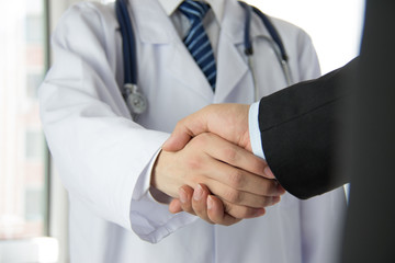 Doctor and businessman shaking hands - 80357750