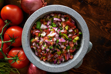 fresh mexican pico de gallo salsa in stone molcajete