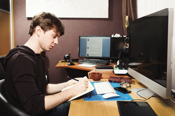 Fototapeta na wymiar Freelance developer and designer working at home, man using desk