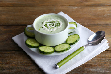 Cucumber soup in bowl on rustic wooden table background
