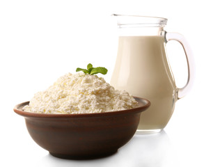 Glass jug of milk and clay bowl of cottage cheese isolated