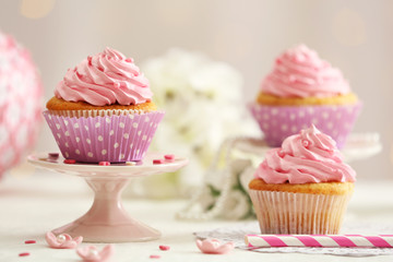 Delicious cupcakes on table on light background