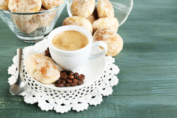 Cup of coffee and tasty cookie on color wooden background