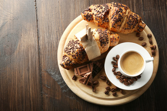 Fresh and tasty croissants with chocolate and cup of coffee