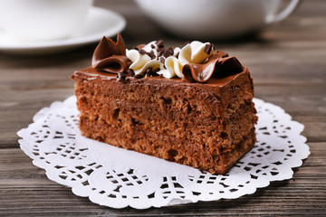 Tasty piece of chocolate cake on wooden table background