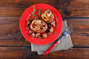 Baked potatoes with mushrooms on pate on wooden table