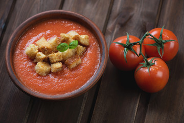 Ceramic bowl with gazpacho over dark rustic wooden background