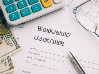 work injury claim form on desk.