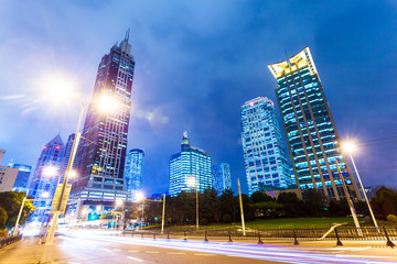 traffic trails and office buildings in modern city.