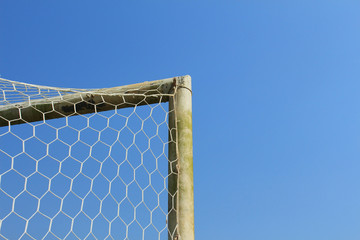 Old soccer goal with blue sky