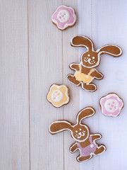 Easter Bunny and flower shaped cookies on the white wooden backg
