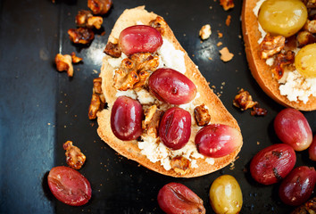 sweet toast with red grape, ricotta, walnut on black baking