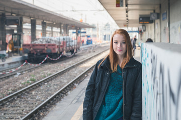 Beautiful girl posing in a railroad station