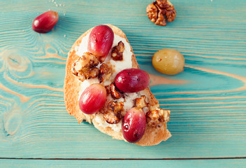 sweet toast with red grape, ricotta, walnut on blue table