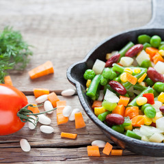 Mixed vegetable meal in old frying pan closeup and ingredients o