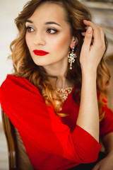 The girl in a red dress with gold costume jewelry