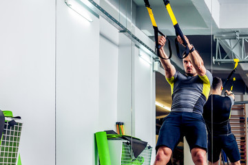 Crossfit instructor at the gym doing TRX Excersise