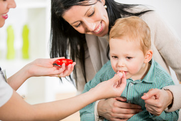 Doctor gives homeopathic pills to child.