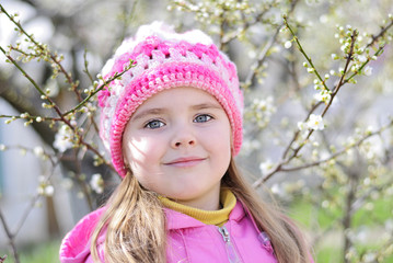 beautiful little girl near a flowering tree