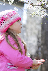 beautiful little girl near a flowering tree