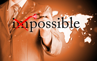 Businessman Hand turning the word Impossible into Possible with