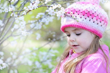 beautiful little girl near a flowering tree