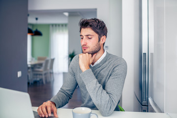 Handsome young concentrated businessman working from home with a
