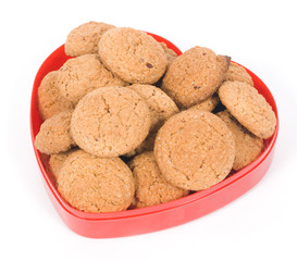 Oatmeal cookies in a red heart pot isolated on white background