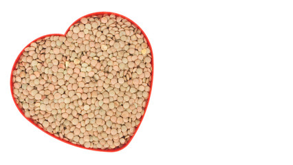 Uncooked lentil in a red heart pot isolated on white background