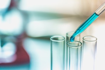 Research. Pipette and test tube on blue background