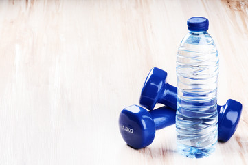 Fitness concept with dumbbells and bottle of water