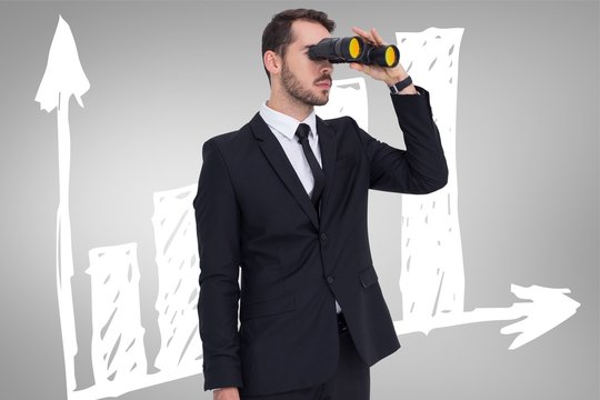 Businessman holding a briefcase while using binoculars