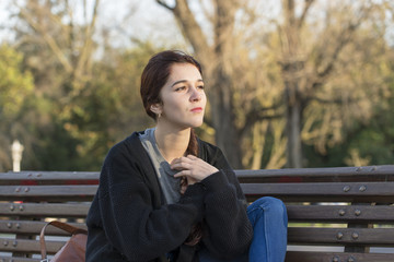 Fototapeta premium Pensive beautiful woman in the park looking away.
